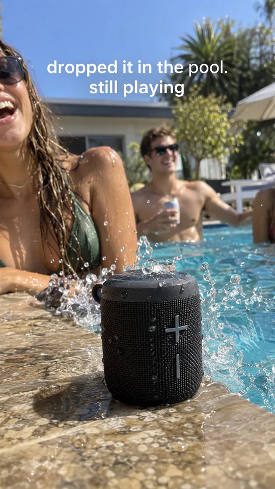 Anuncio UGC de TikTok de amigos riendo en una piscina con un altavoz portátil en el borde, con el texto se me cayó a la piscina. sigue sonando