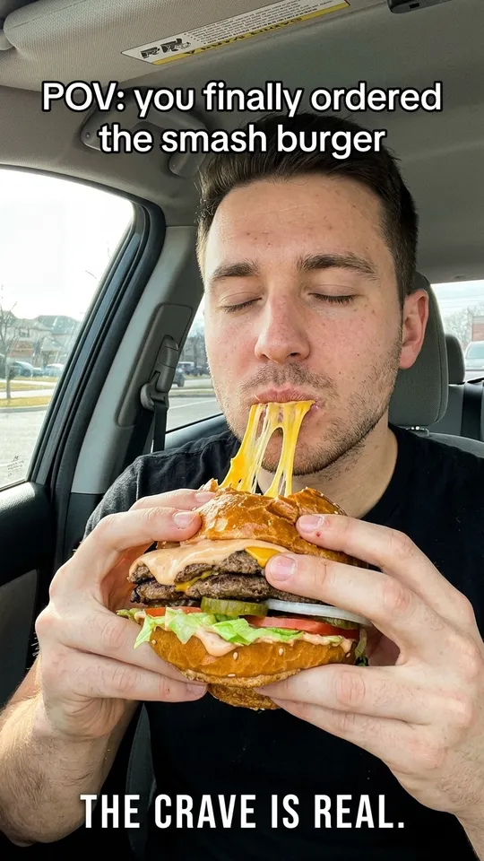 Anuncio UGC de TikTok de un hombre en su coche mordiendo una smash burger con queso, con el texto POV: por fin pediste la smash burger