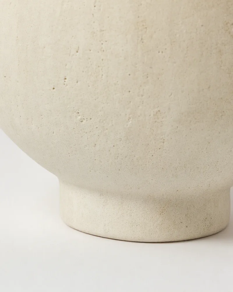 Close-up of the speckled cream matte glaze and the foot of a stoneware vase