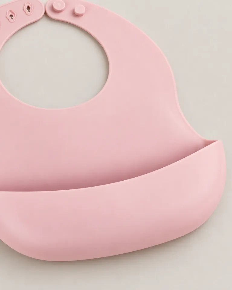 Primer plano del bolsillo recogemigas del babero de silicona rosa