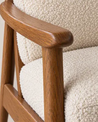 Primer plano de la veta del reposabrazos de roble y el tejido bouclé color crema