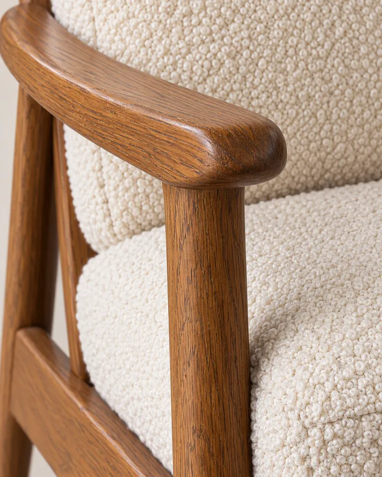 Primer plano de la veta del reposabrazos de roble y el tejido bouclé color crema