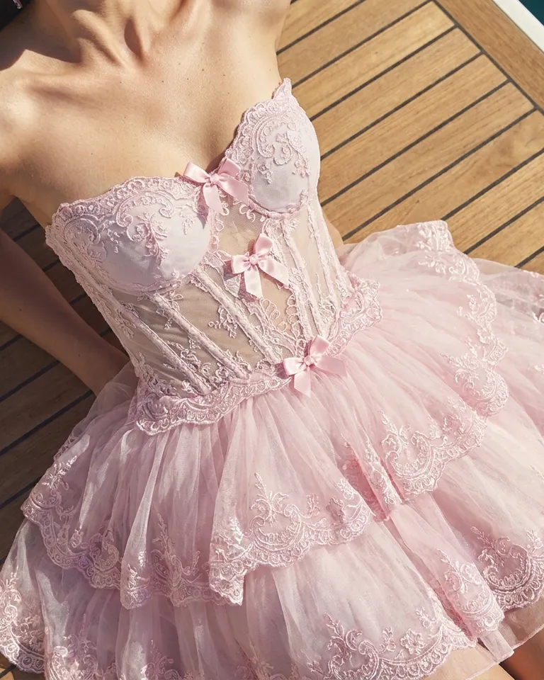 Encuadre cerrado del vestido corsé de encaje rosa en una modelo sobre la cubierta de un barco