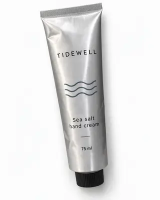 Crema de manos con sal marina Tidewell en un tubo de aluminio plateado sobre fondo blanco