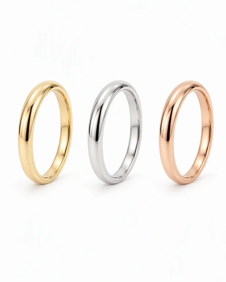 Tres anillos finos apilables en oro, plata y oro rosa colocados en fila sobre fondo blanco