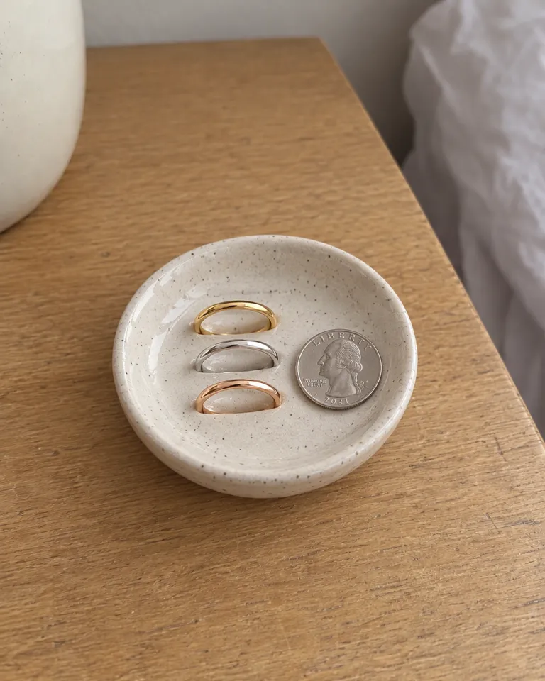 Los tres anillos apilables en un pequeño plato de cerámica junto a una moneda