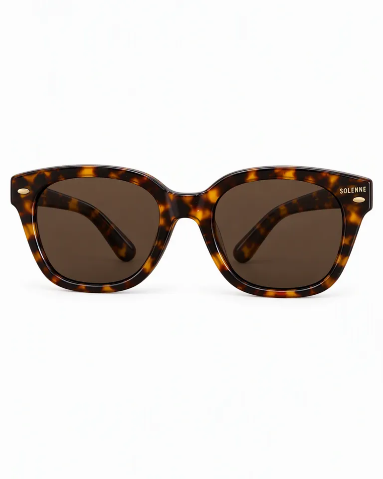 Gafas de sol de acetato de carey con las patillas plegadas sobre fondo blanco