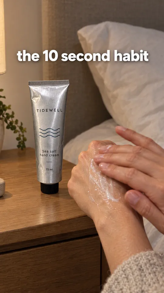 TikTok with the hook "the 10 second habit": hands rubbing in the Tidewell hand cream beside the tube on a bedside table