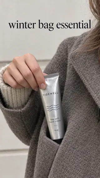 Instagram Story with "winter bag essential" written across it: a woman pulling the Tidewell hand cream tube out of her coat pocket