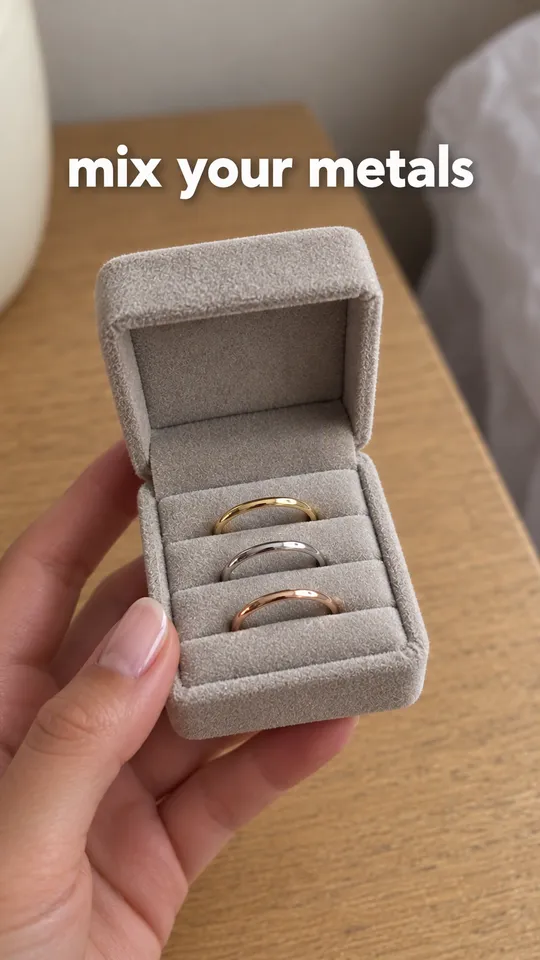 TikTok with the hook "mix your metals": a hand turning slowly to show the three stacked rings catching light