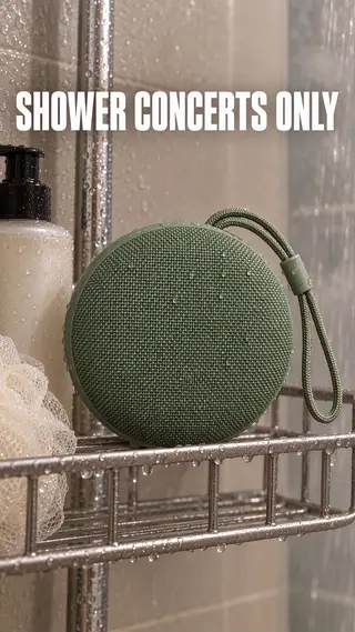 Instagram Story with "shower concerts only" written across it: the sage green speaker on a shower caddy in a steamy bathroom